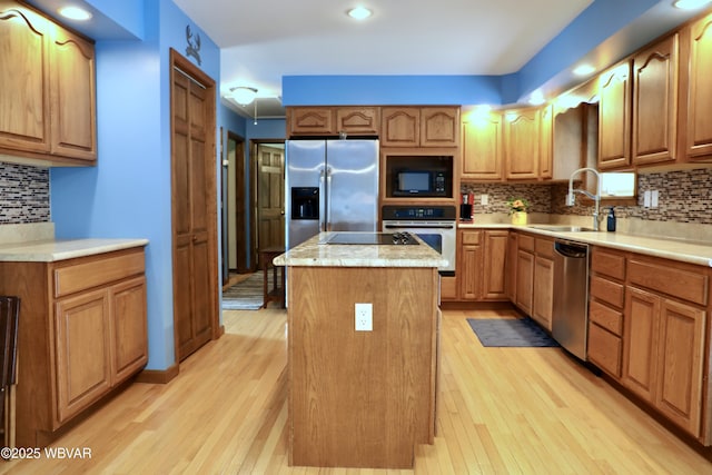 82 Woodside Cir, Jersey Shore, PA 17740 - kitchen featuring appliances with stainless steel finishes, a center island, a sink, decorative backsplash, and light wood finished floors