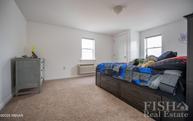 bedroom with a wall unit AC, light carpet, and baseboards