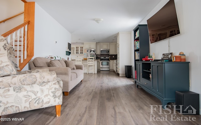 living area featuring light wood finished floors and stairs