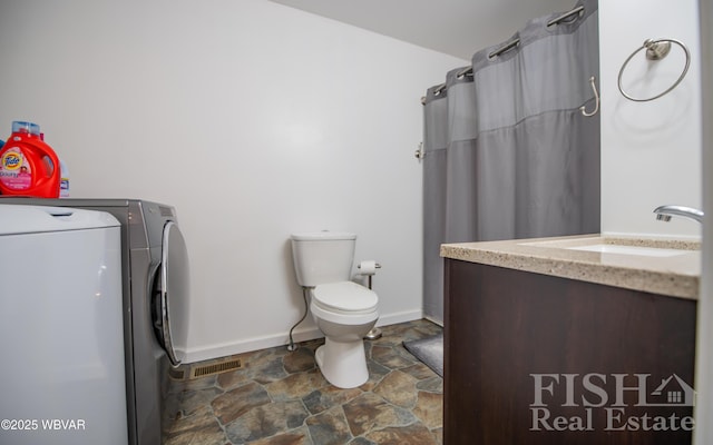 full bathroom with visible vents, toilet, stone finish floor, washer / clothes dryer, and vanity