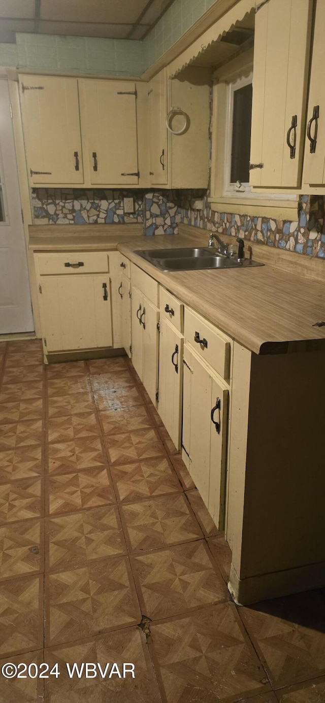 kitchen featuring tasteful backsplash, sink, and light parquet floors