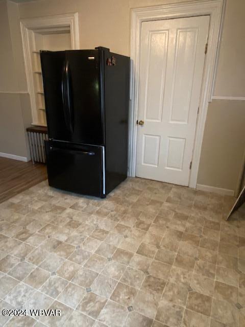 kitchen with black refrigerator and radiator