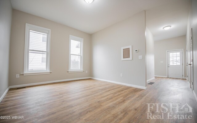 spare room with light wood-style flooring, visible vents, and baseboards