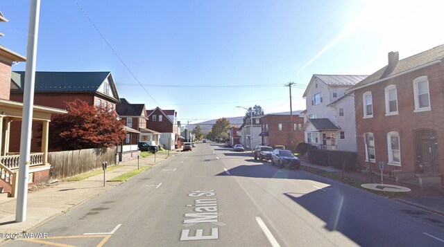 view of road with curbs, street lighting, sidewalks, and a residential view