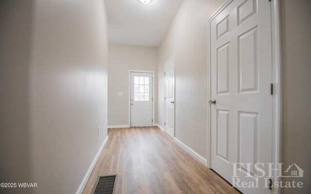 doorway with visible vents, baseboards, and wood finished floors