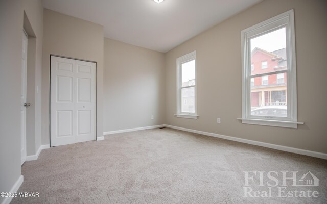 unfurnished bedroom featuring a closet, baseboards, and carpet flooring