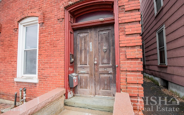 view of exterior entry featuring brick siding