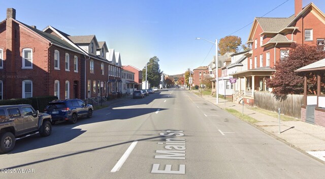 view of road featuring sidewalks, street lighting, a residential view, and curbs