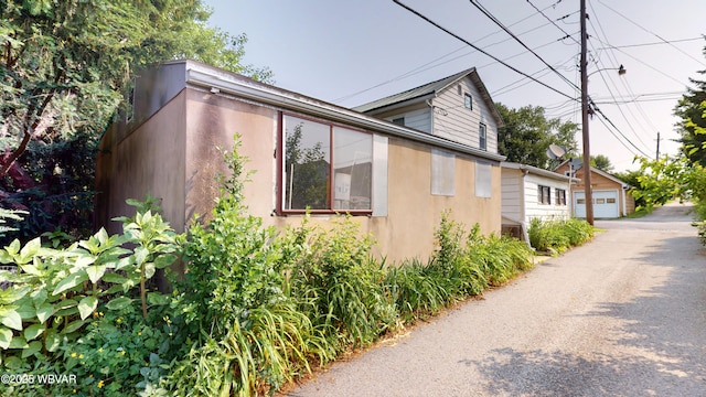 123 Broad St, Watsontown, PA 17777 - view of side of home with stucco siding and a garage