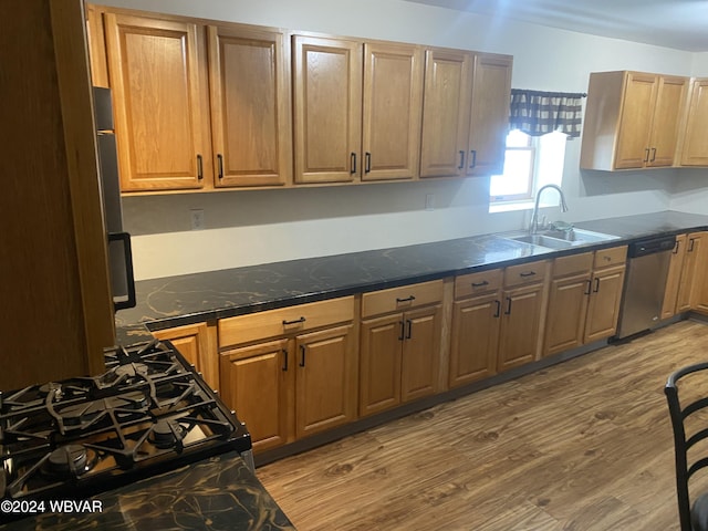 kitchen featuring hardwood / wood-style flooring, dishwasher, sink, and black range with gas cooktop