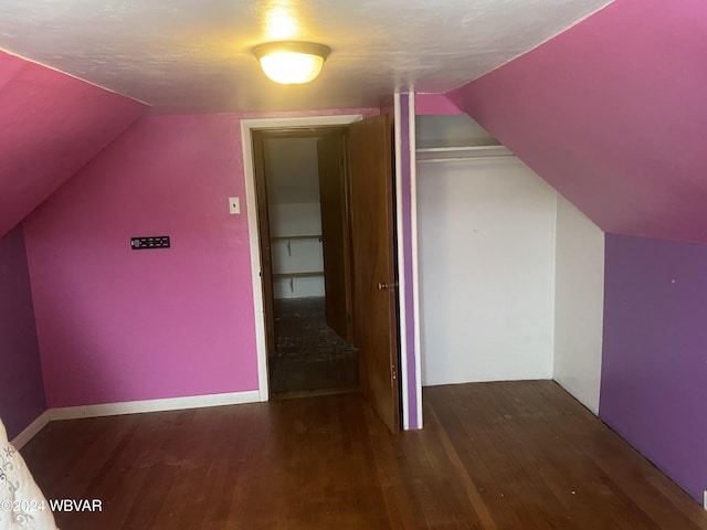 additional living space with dark hardwood / wood-style floors and vaulted ceiling