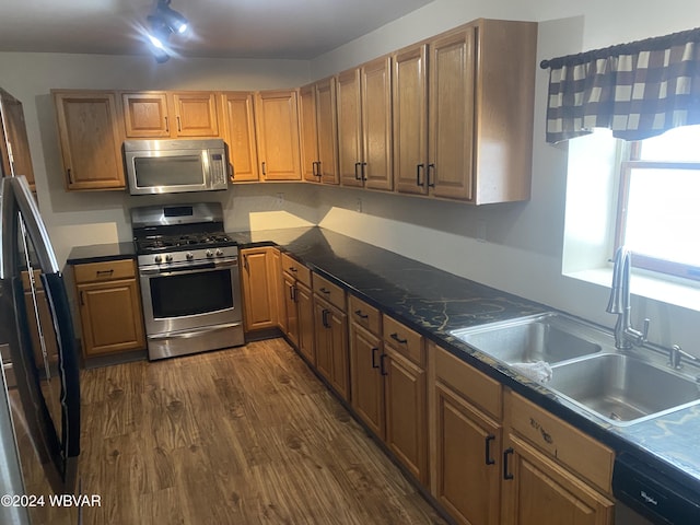 kitchen featuring dark hardwood / wood-style flooring, stainless steel appliances, and sink