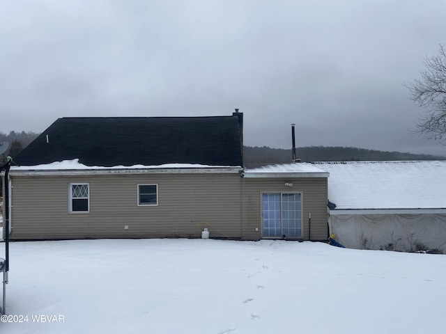 view of snow covered rear of property