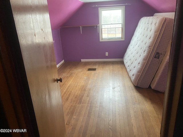 additional living space featuring light hardwood / wood-style flooring and vaulted ceiling