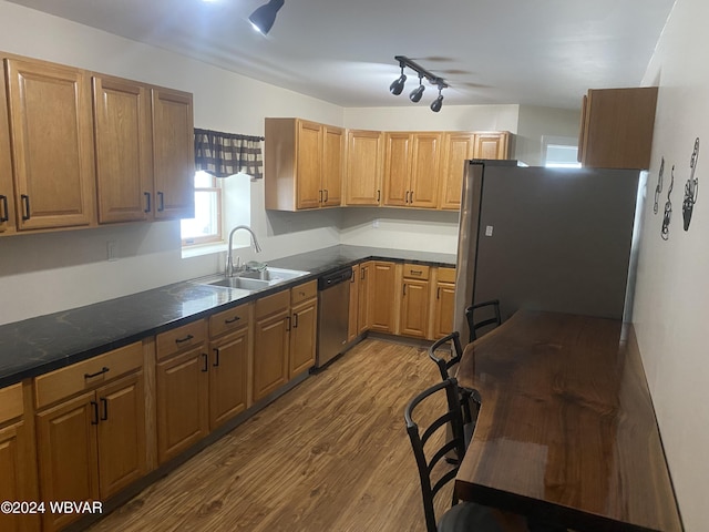 kitchen featuring stainless steel appliances, light hardwood / wood-style floors, and sink