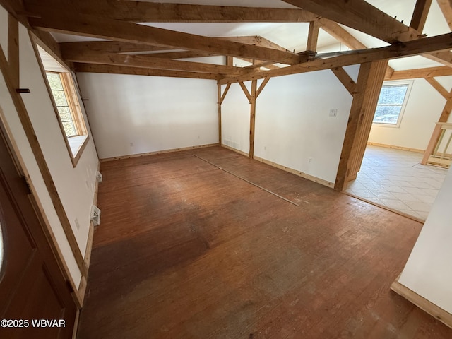 unfurnished room with ceiling fan, lofted ceiling with beams, and hardwood / wood-style floors