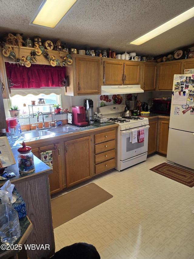 kitchen featuring sink, a textured ceiling, and white appliances