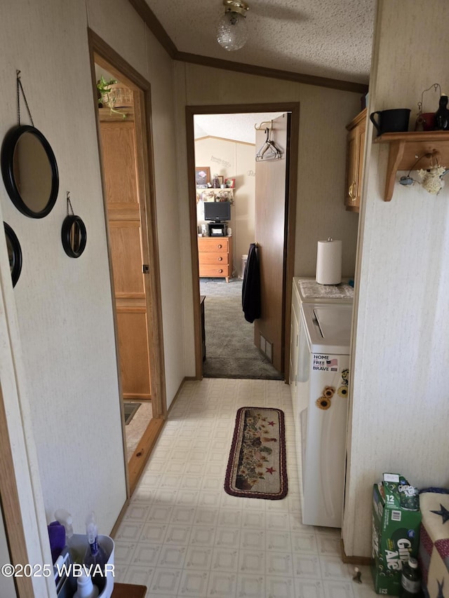 interior space with separate washer and dryer, ornamental molding, and a textured ceiling