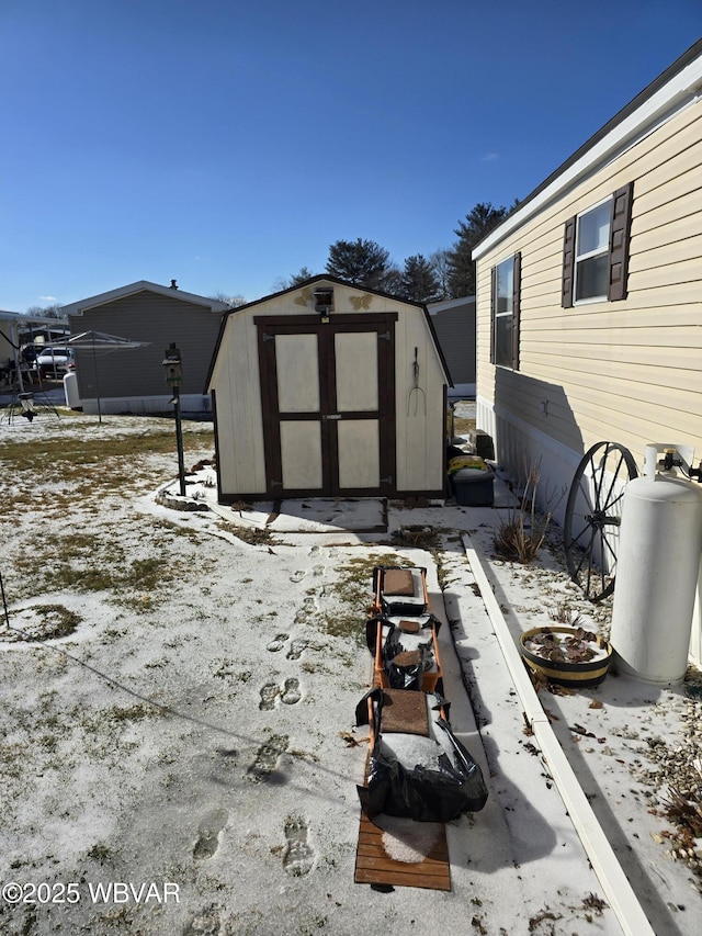 snow covered patio featuring a storage shed