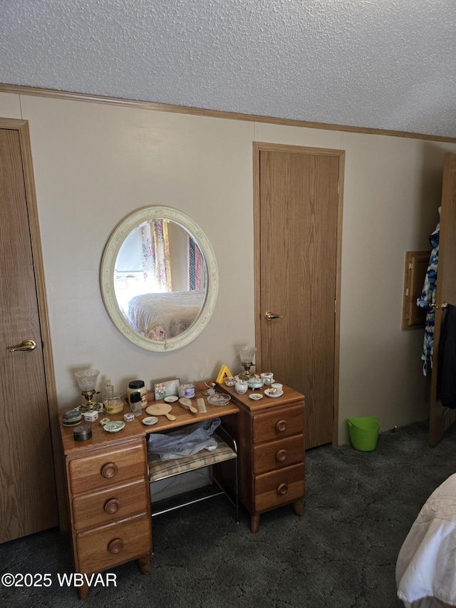 bedroom with ornamental molding, a textured ceiling, and dark carpet