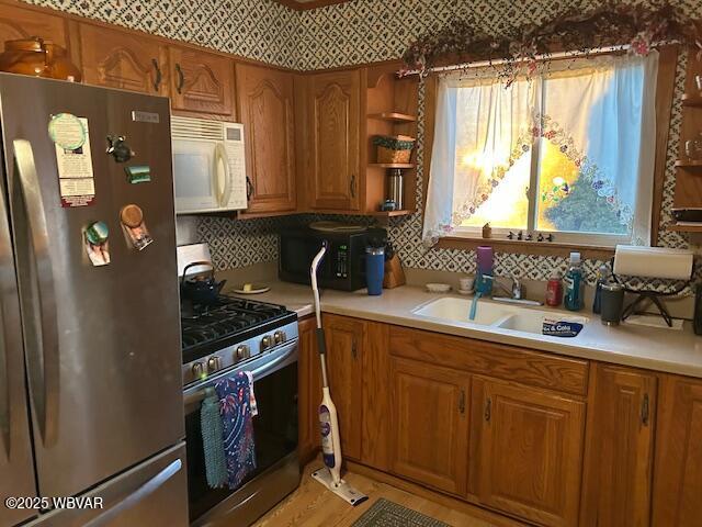 kitchen featuring stainless steel appliances, sink, and backsplash