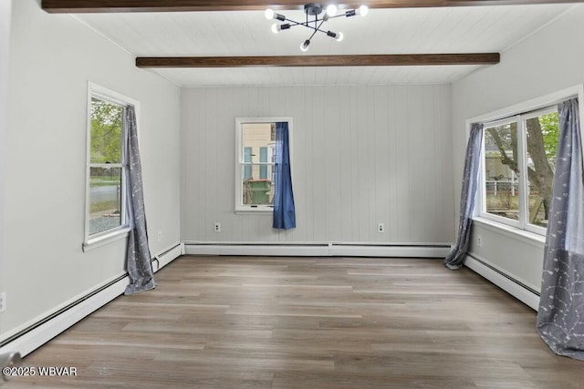 unfurnished room featuring a baseboard heating unit, beam ceiling, a chandelier, and a healthy amount of sunlight