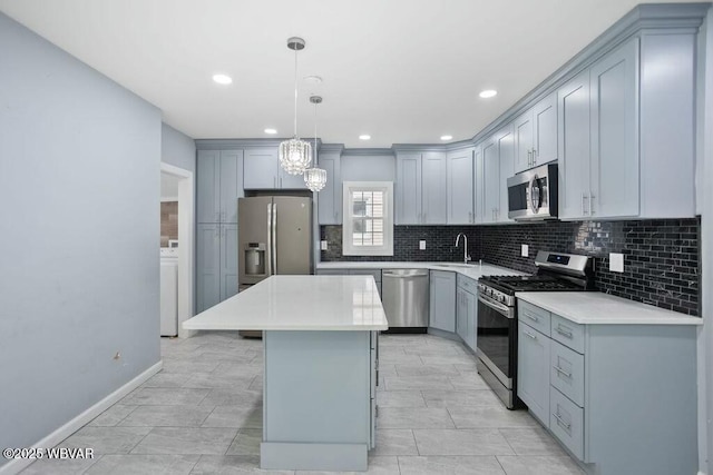 kitchen featuring stainless steel appliances, an inviting chandelier, a kitchen island, gray cabinetry, and tasteful backsplash