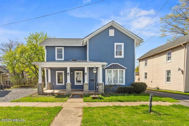 traditional-style house featuring a porch and a front lawn