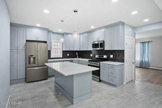 kitchen featuring a center island, light countertops, appliances with stainless steel finishes, and tasteful backsplash