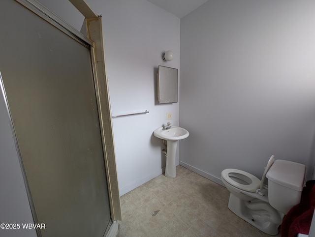 bathroom featuring baseboards, toilet, and an enclosed shower