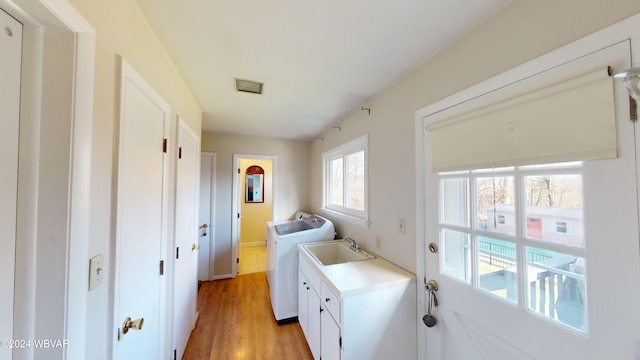 washroom with washer and clothes dryer, sink, and light hardwood / wood-style flooring