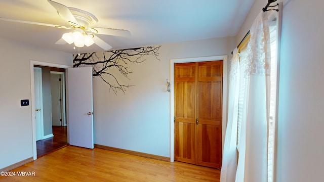 unfurnished bedroom featuring light hardwood / wood-style flooring, a closet, and ceiling fan