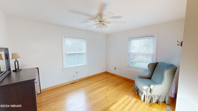 living area featuring ceiling fan and wood-type flooring