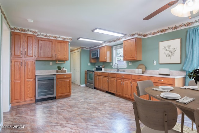 kitchen with beverage cooler, stainless steel appliances, light countertops, and a sink