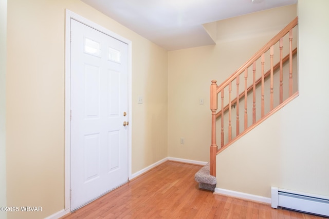 entryway featuring stairway, wood finished floors, a baseboard heating unit, and baseboards