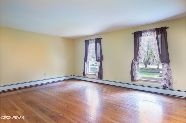 spare room with wood finished floors and baseboard heating