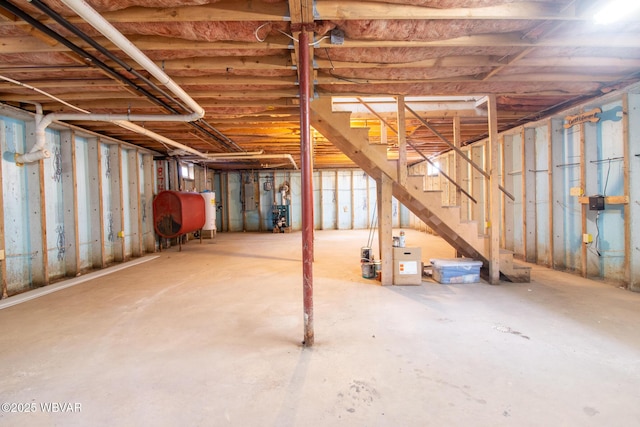 unfinished below grade area with heating fuel, stairway, and water heater