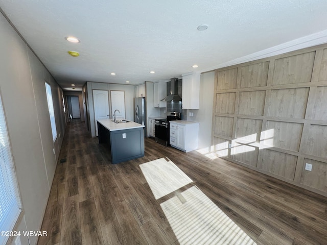 kitchen featuring stainless steel appliances, an island with sink, white cabinets, dark hardwood / wood-style flooring, and wall chimney exhaust hood