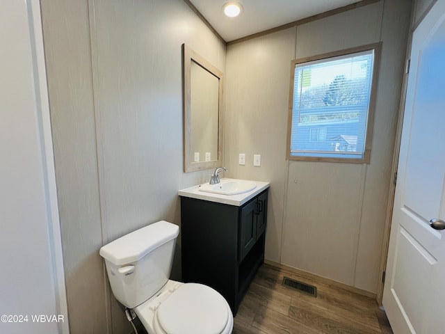 bathroom with vanity, toilet, and hardwood / wood-style floors