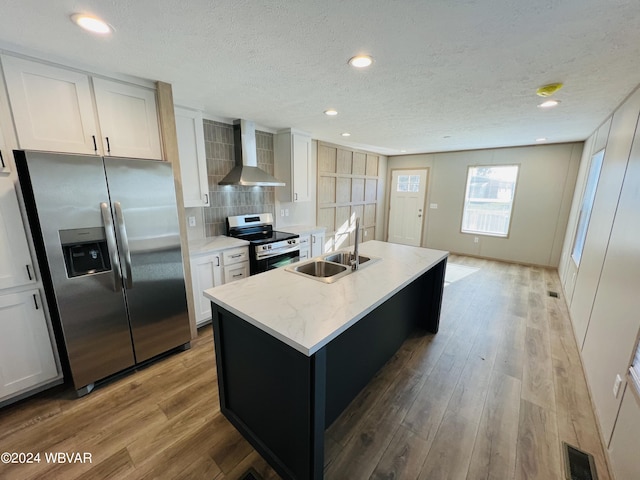 kitchen featuring appliances with stainless steel finishes, white cabinets, and wall chimney exhaust hood