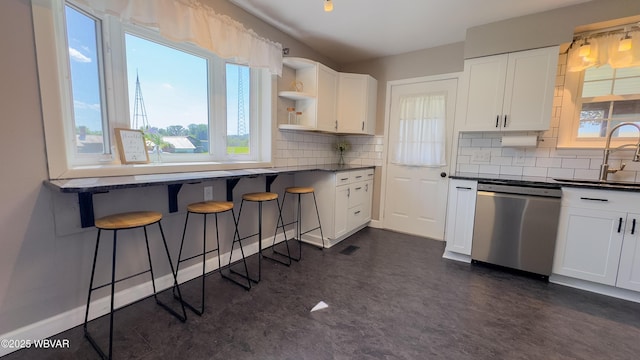 1945 Eagle Valley Rd, Beech Creek, PA 16822 - kitchen with stainless steel dishwasher, dark countertops, white cabinetry, and a breakfast bar area