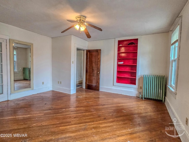 345 W Main St, Lock Haven, PA 17745 - empty room featuring radiator heating unit, built in shelves, wood finished floors, and ceiling fan