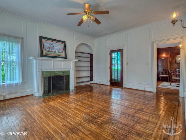 345 W Main St, Lock Haven, PA 17745 - unfurnished living room with a decorative wall, built in features, ornamental molding, a ceiling fan, and hardwood / wood-style flooring