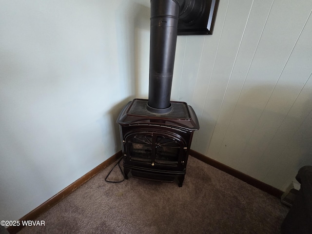 details with a wood stove, baseboards, and carpet floors