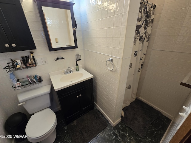 full bathroom with vanity, tile walls, toilet, and tiled shower