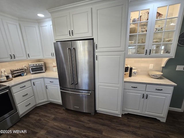 kitchen with white cabinets, appliances with stainless steel finishes, glass insert cabinets, and dark wood-style flooring