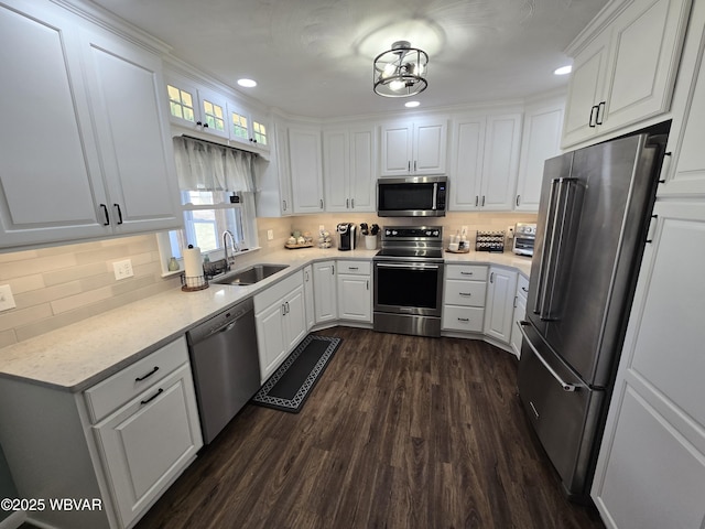 kitchen featuring a sink, appliances with stainless steel finishes, dark wood-style floors, and white cabinetry