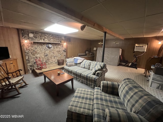 carpeted living room featuring wooden walls, beamed ceiling, and a wall unit AC