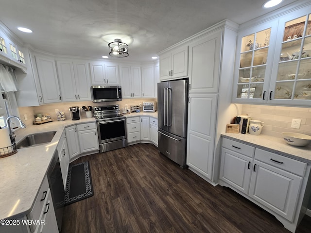 kitchen featuring a sink, dark wood-style floors, appliances with stainless steel finishes, and white cabinets