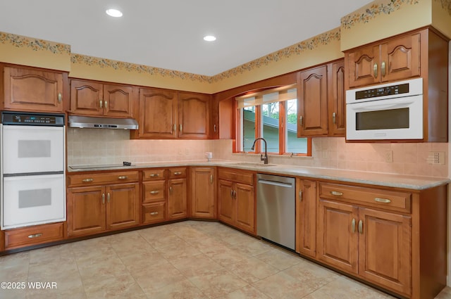 316 Winter St, Duboistown, PA 17702 - kitchen with stainless steel dishwasher, a sink, brown cabinets, under cabinet range hood, and double oven